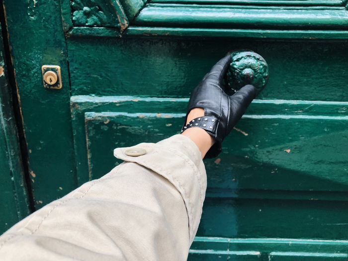 Hand opening a green door