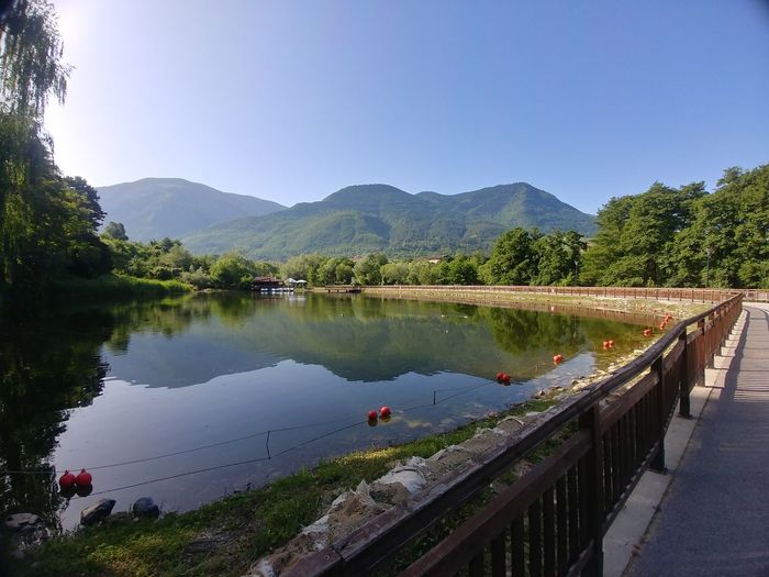 Scenic view of lake and mountains against clear sky