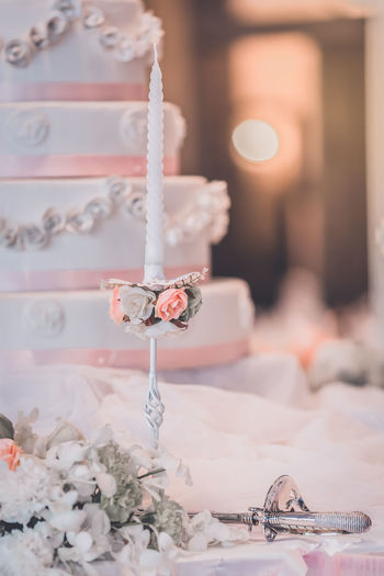 Close-up of candle and wedding cake on table
