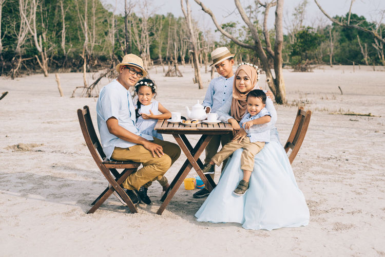 Portrait of family having breakfast while sitting on field
