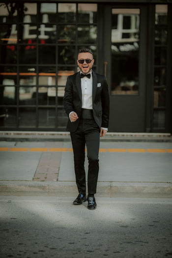 Full length portrait of young man standing in city