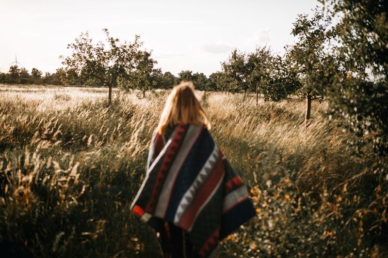 Rear view of woman walking on field