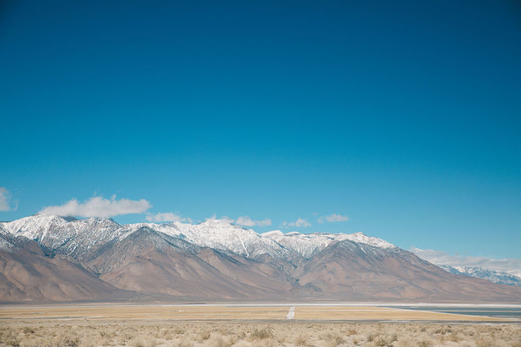 Scenic view of mountains against blue sky