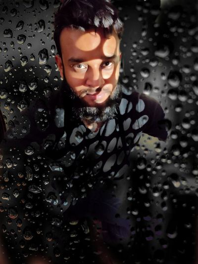Portrait of wet man standing in rain
