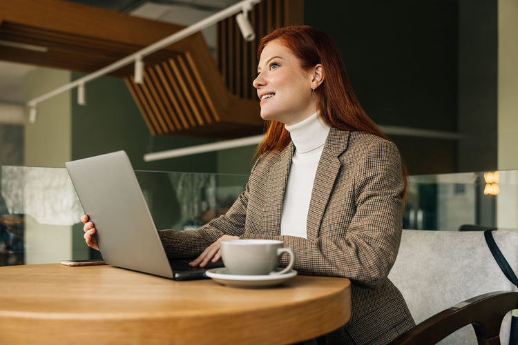 Young woman using laptop at table