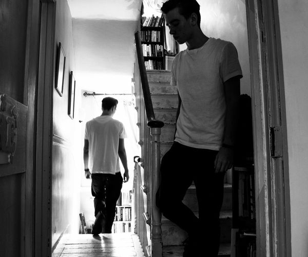 Rear view of men standing in corridor