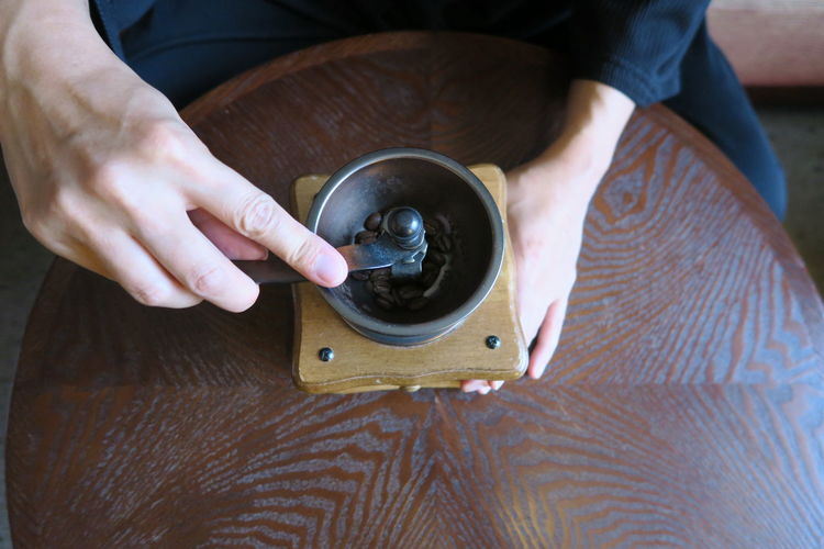 High angle view of person grinding coffee on table