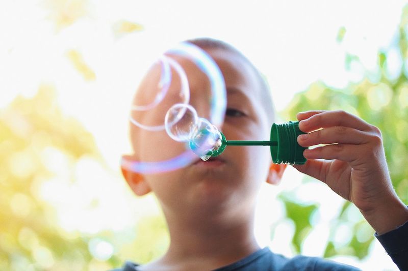 Close-up of boy blowing bubbles
