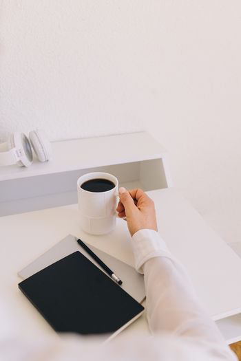 Cropped hand of woman using laptop on table