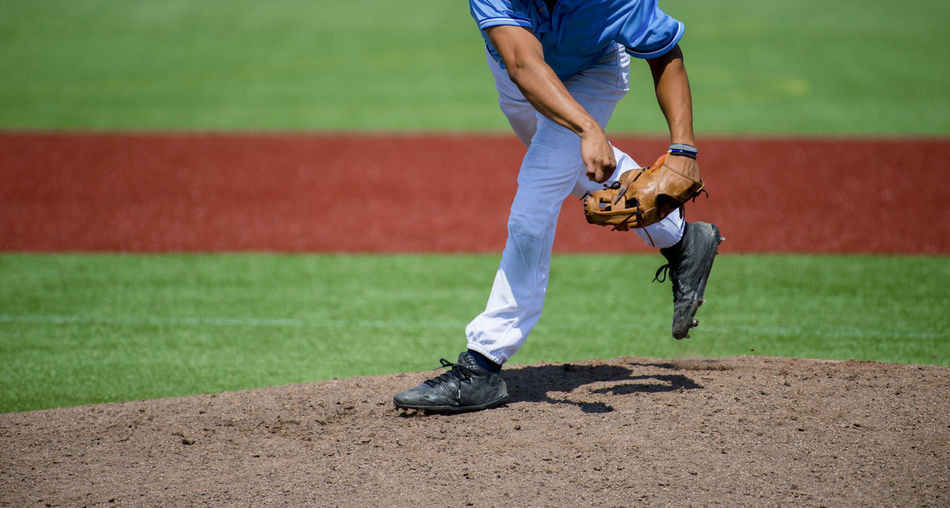 Low section of man playing baseball on field
