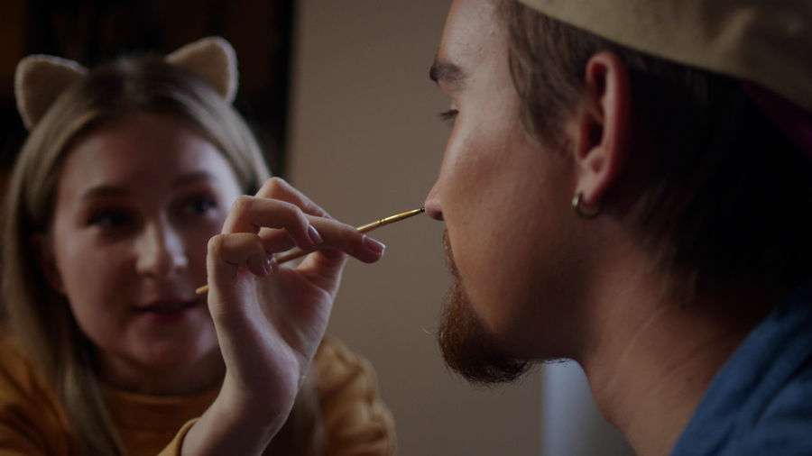Side view of young woman applying nail