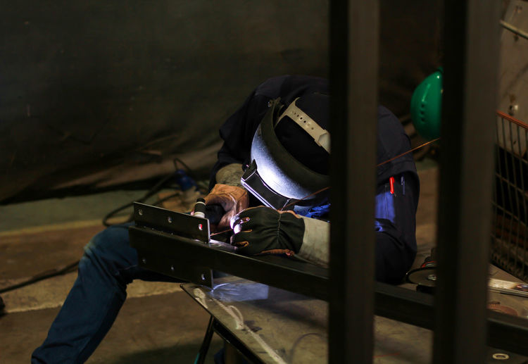 Male worker welding metal in workshop