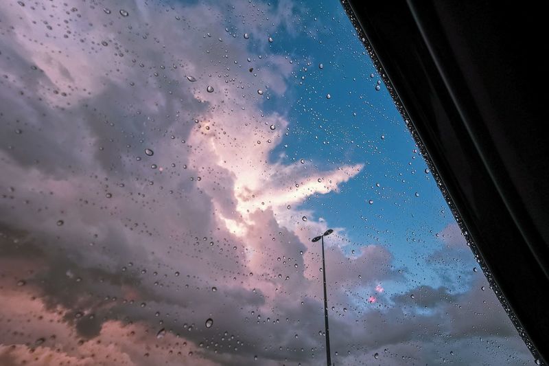 Sky seen through wet glass window