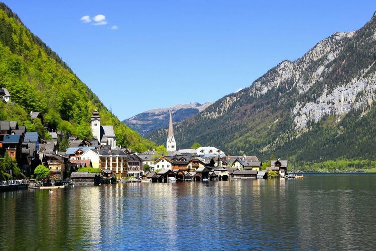Buildings by lake against mountains
