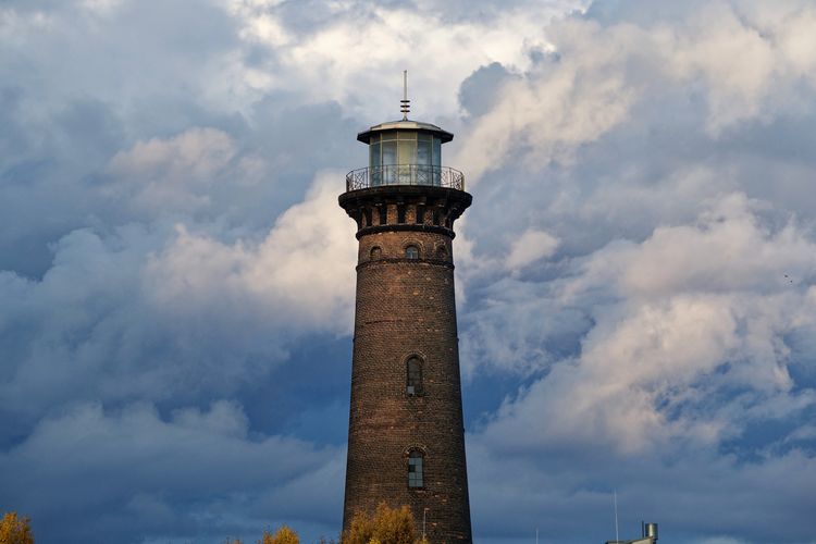 Historical old lighthouse against dark storm clouds