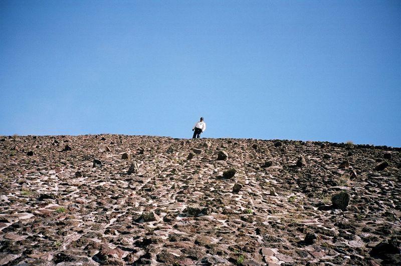 Low angle view of man standing over hill 