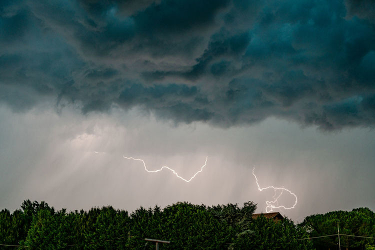 Low angle view of lightning in sky at dusk