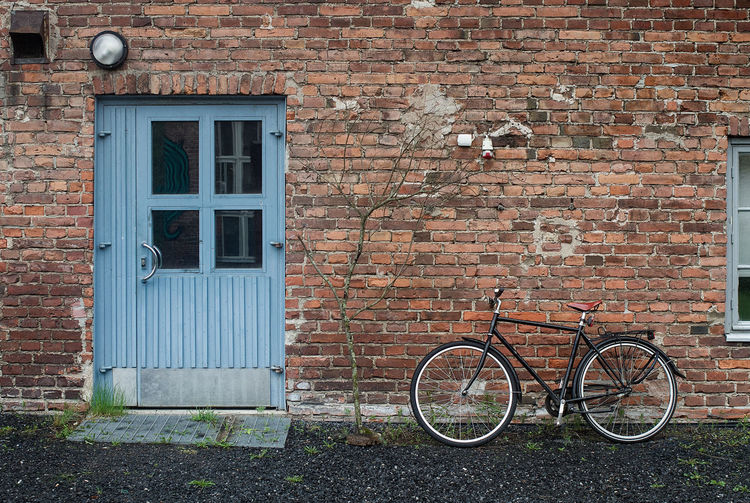 Bicycle against brick wall of building