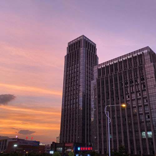 Low angle view of illuminated buildings against sky during sunset