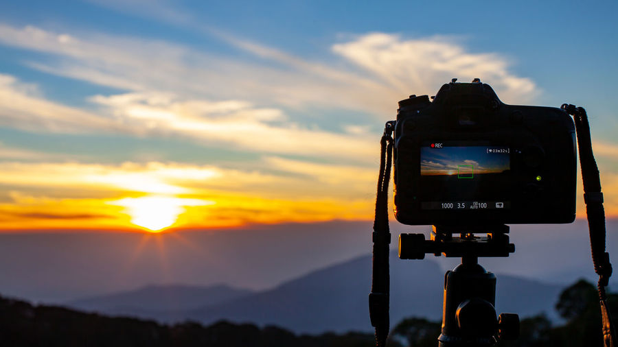 Digital camera against sky during sunset
