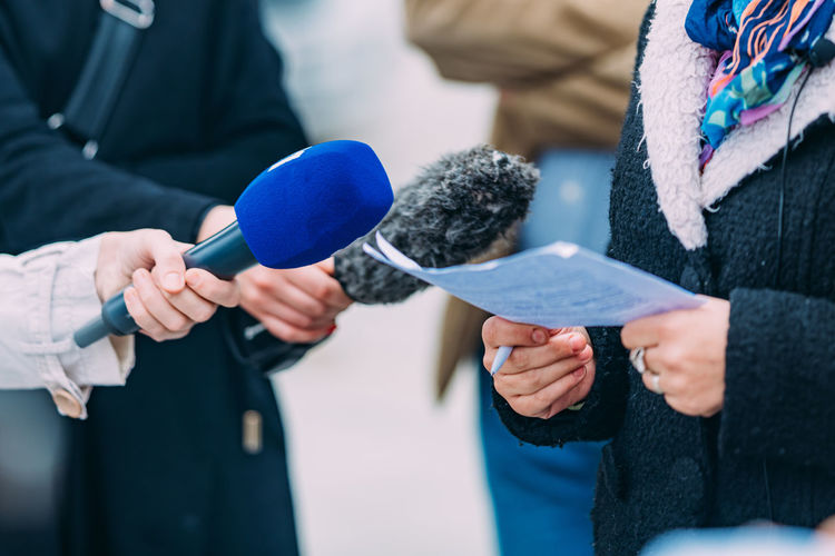 Midsection of man holding microphone