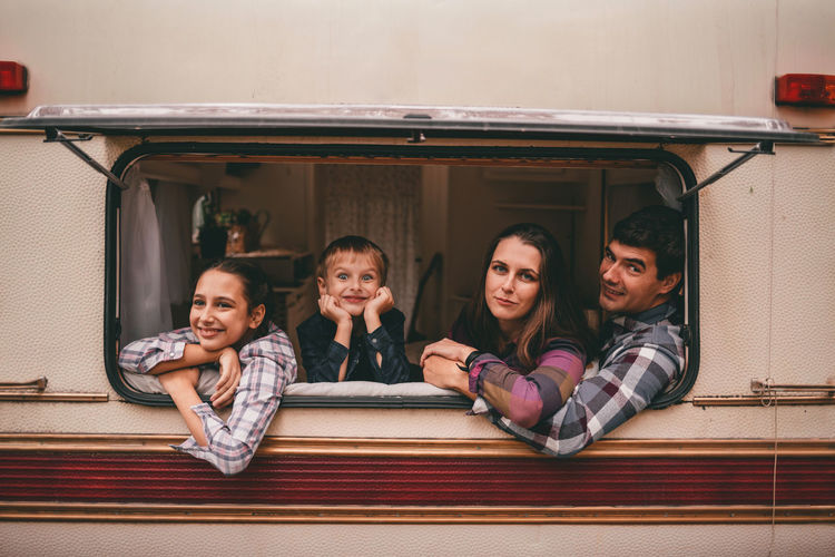 Happy family on camping trip relaxing in the autumn forest camper trailer fall season outdoors trip