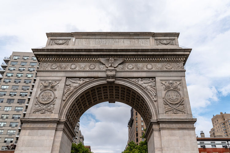 Low angle view of washington square arch against sky in city