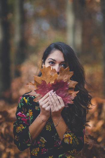 Portrait of woman holding autumn leaf