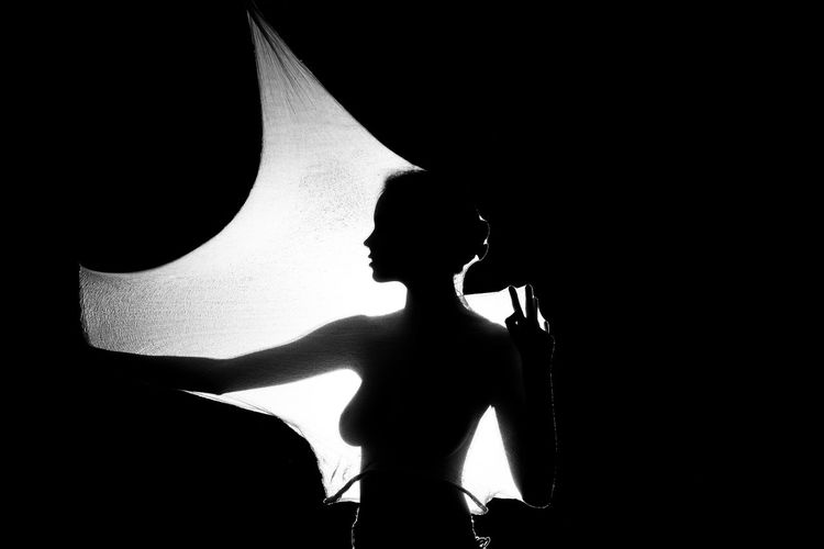 Silhouette of woman against black background