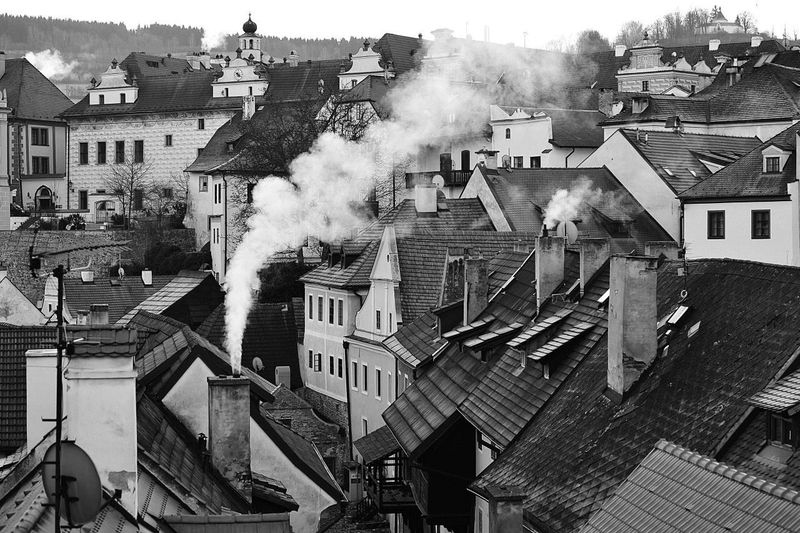 Smoke emitting chimneys on roof in town