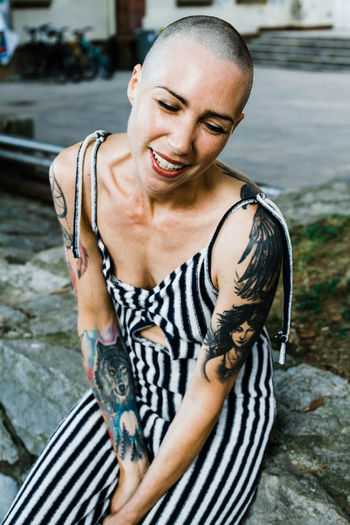 Young woman with shaved head smiles