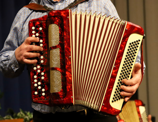 Midsection of man playing accordion 