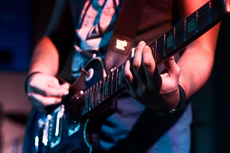 Midsection of person playing guitar