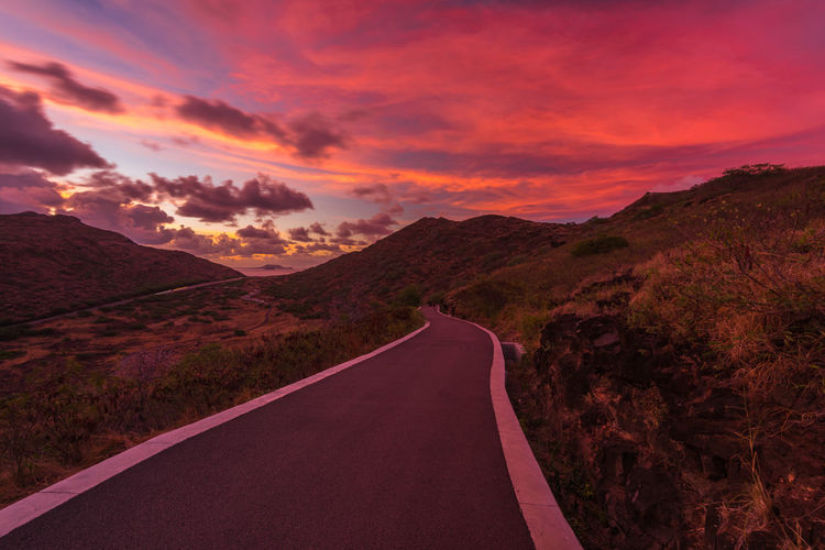 Road amidst landscape against sky during sunset