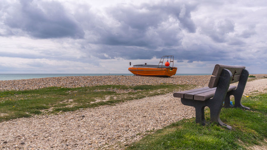 Boat moored at sea shore against sky