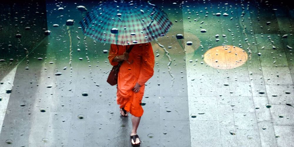 Woman walking on wet glass during rainy season