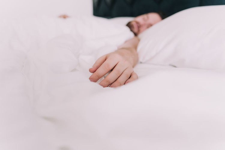 Low section of man lying on bed