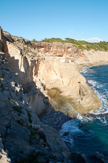 Vertical view, old abandoned quarry, of marés stone blocks, on the cliff of the mediterranean sea,