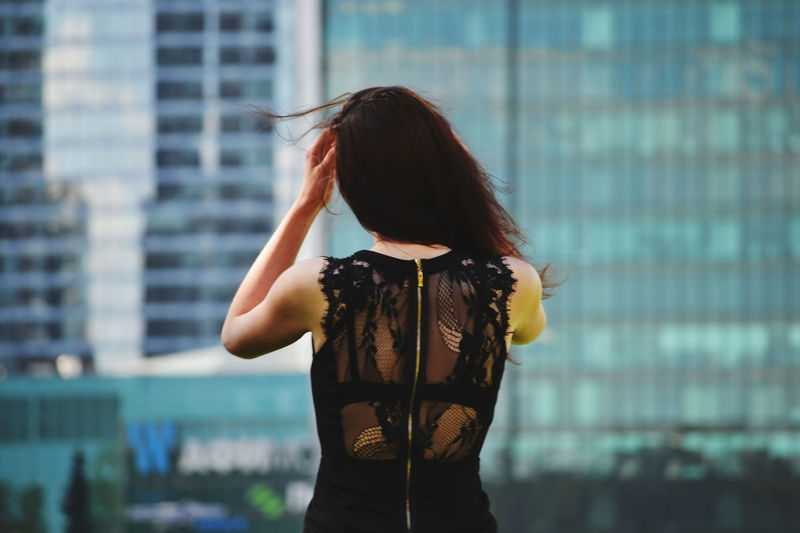 Rear view of woman standing against built structure
