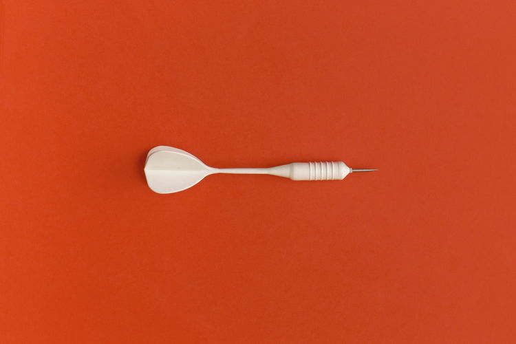 Dart on a red background. top view. flat lay.