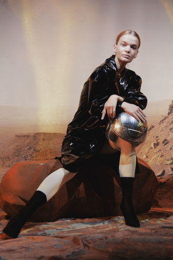 Young woman sitting on wall