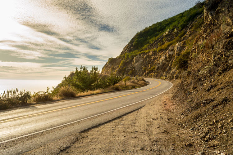 Winding sunset and ocean road in big sur, coastal highway one in california, usa