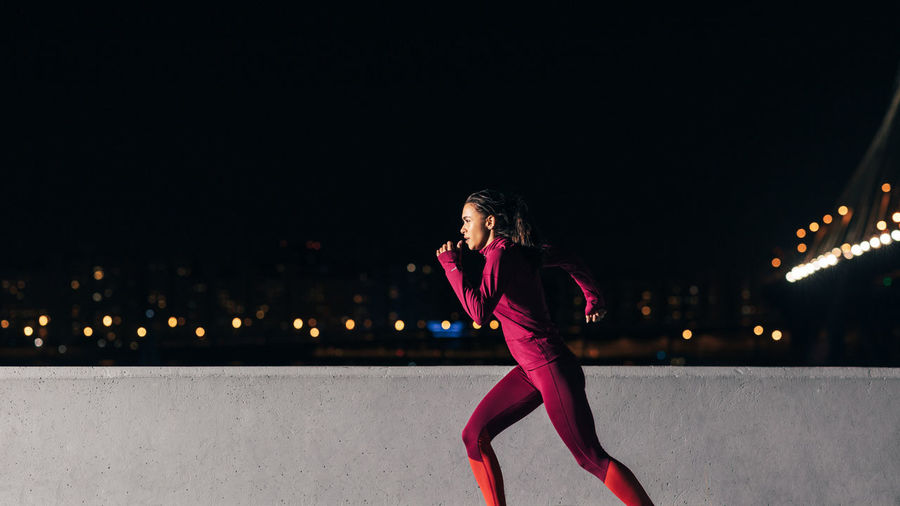 Young female jogger exercising in the evening. woman running at embankment.	