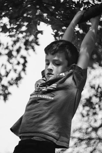 Boy hanging on railing in playground