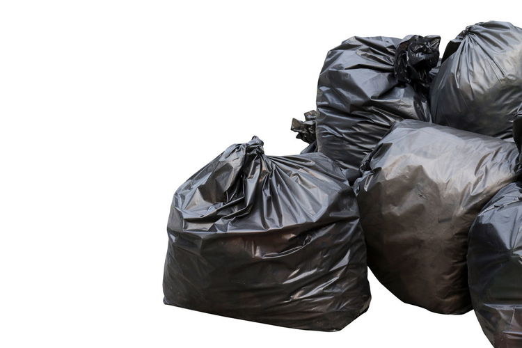 Close-up of garbage bags on white background