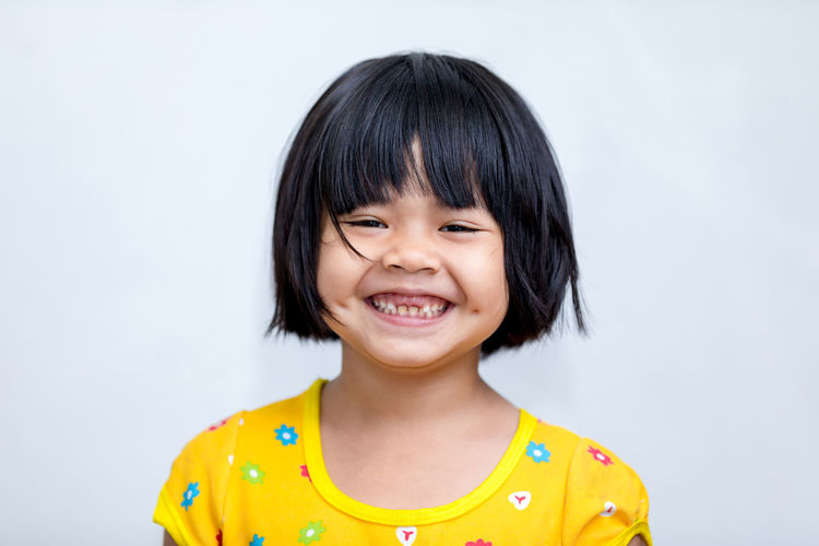 Portrait of smiling girl against white background