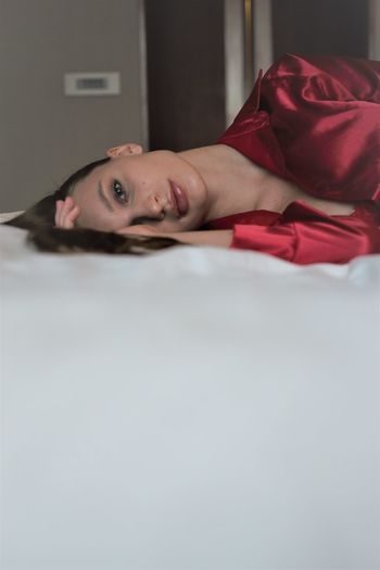 Portrait of woman lying on bed at home