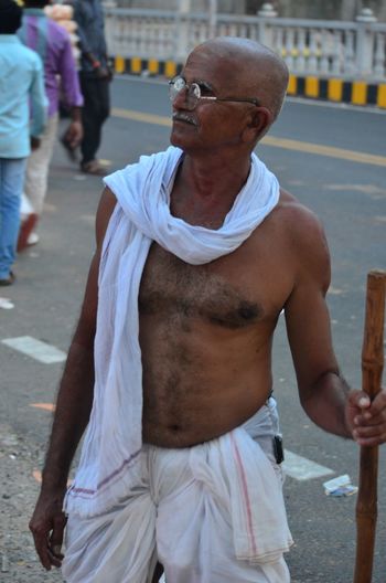 Senior man in costume standing on street