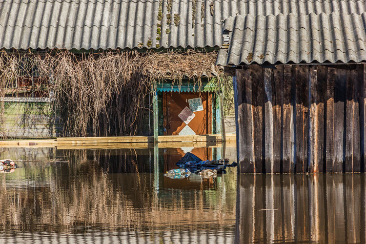 Reflection of man on roof at lake