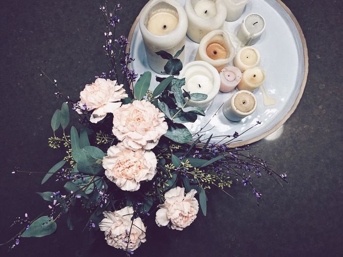 High angle view of white flowers with candles on table